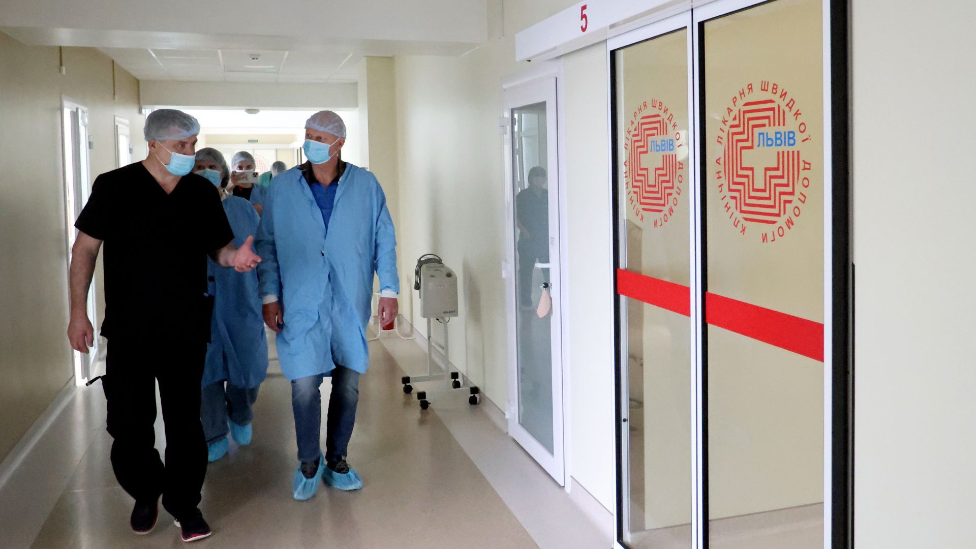 Люди в масках і сітках для волосся йдуть проходом Центру голови та шиї.